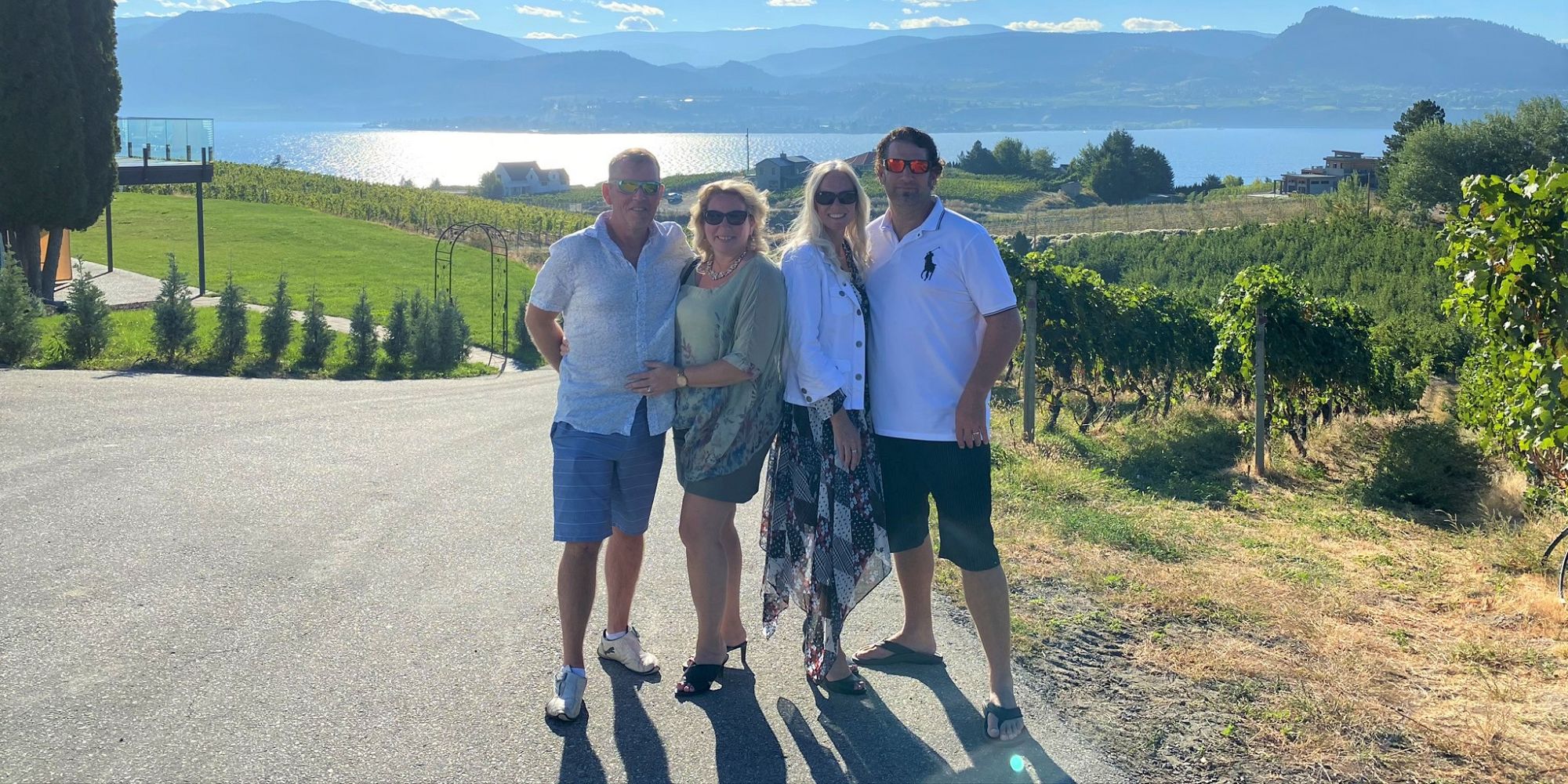 Two Couples At Therapy Vineyards Overlooking The Vines And Lake Okanagan