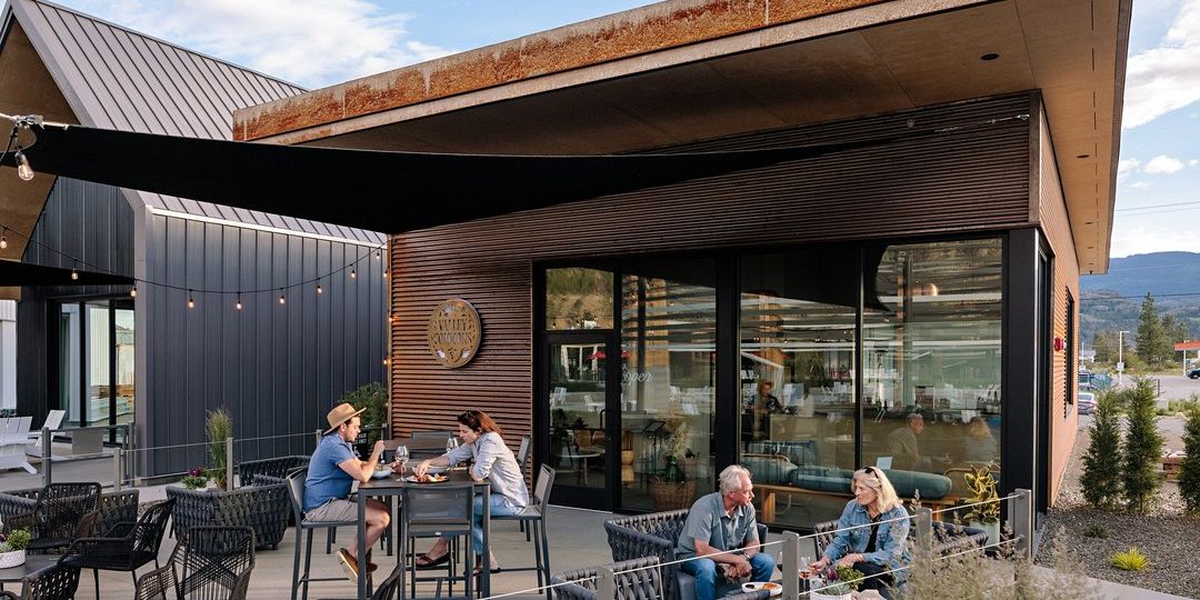 Two Separate Groups Of People Enjoying Private Seated Wine Tastings On The Patio At The District Wine Village