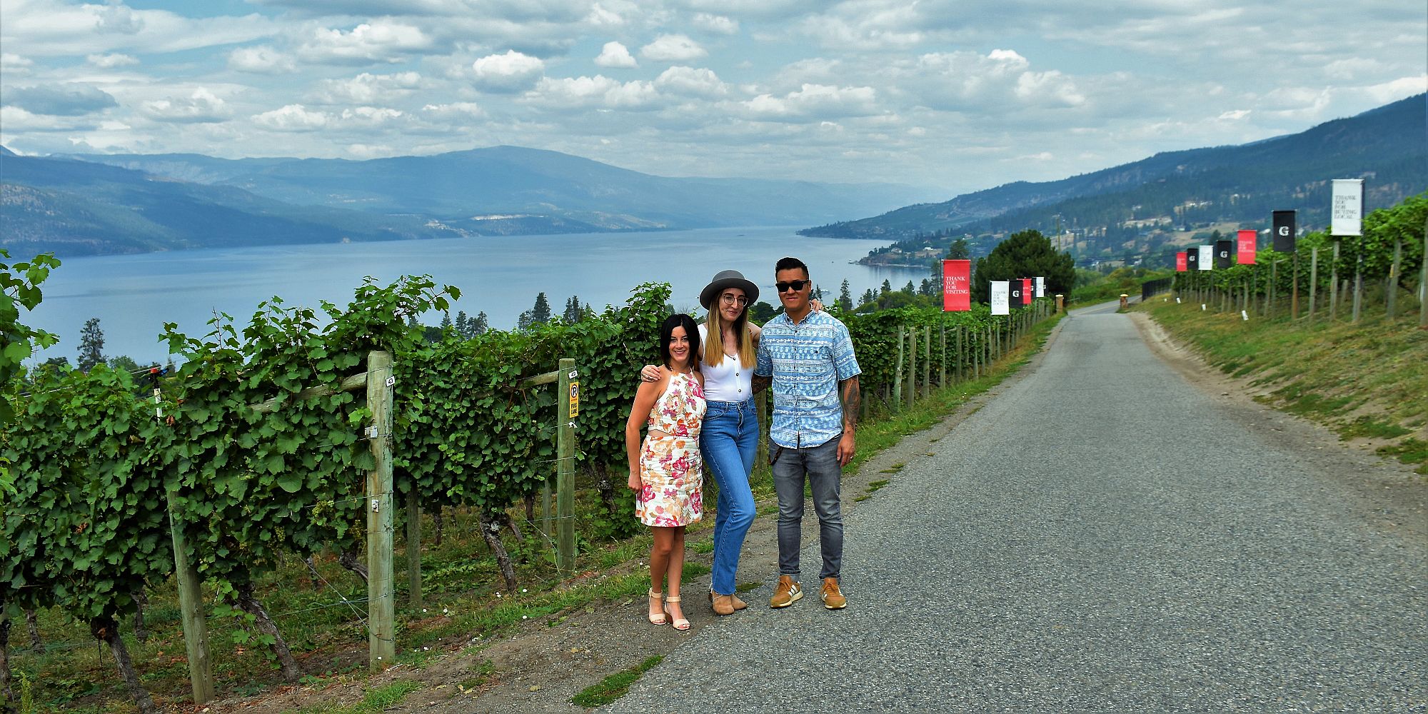 Three Friends Standing Next To Pinot Gris Vines At Gray Monk Estate Winery
