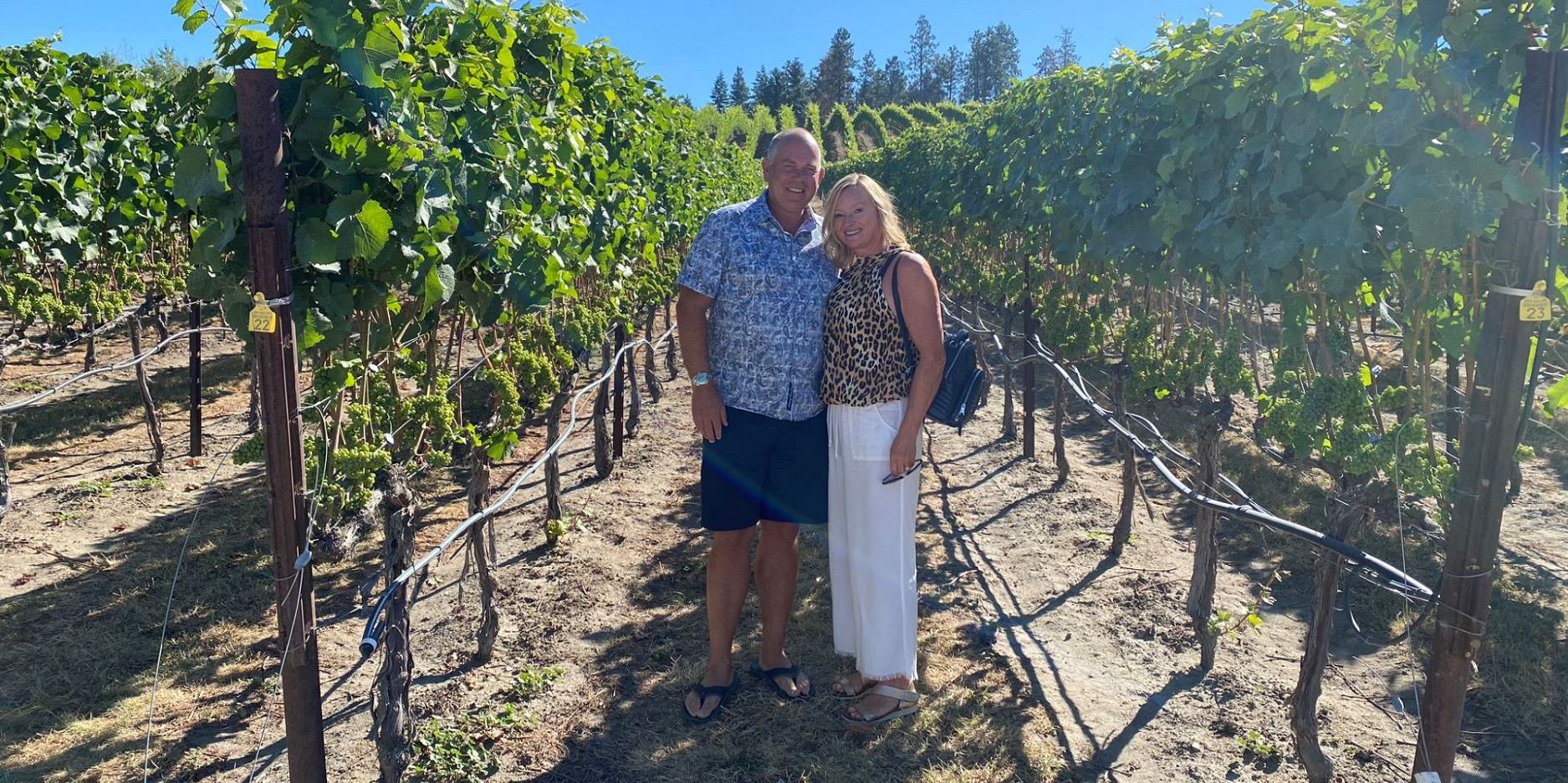 A Couples Standing Next To Pinot Noir Vines At Ex Nihilo Vineyards