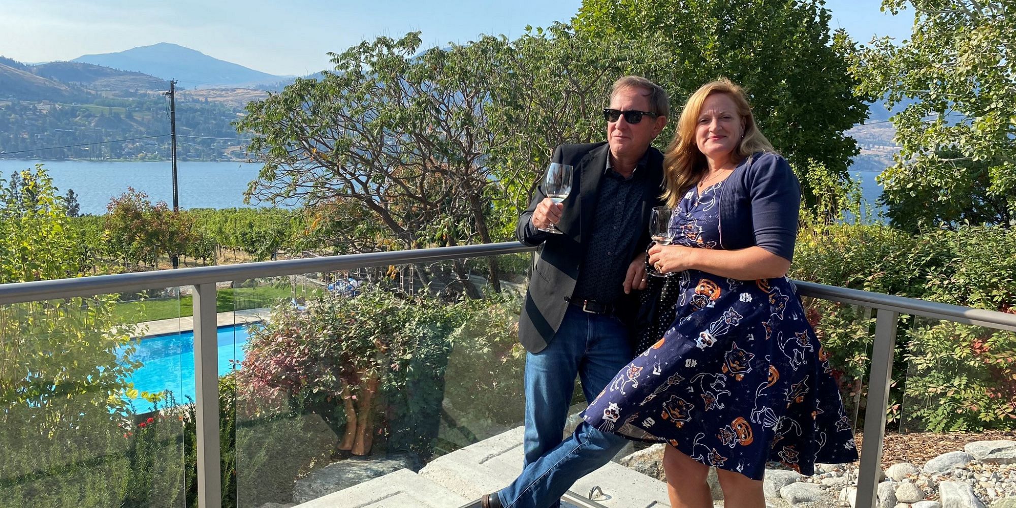Couple Standing With Wine On The Patio At Blasted Church Vineyard Overlooking A Pool