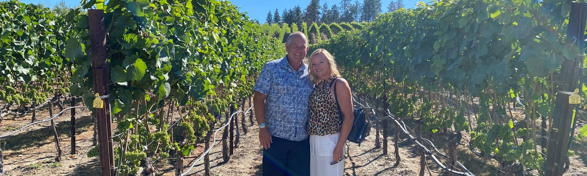 Classy couple enjoying their private wine tour for their anniversary while posing in the vines at Ex Nihilo Vineyards.