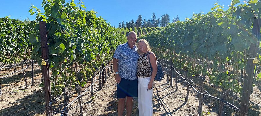 Classy couple enjoying their private wine tour for their anniversary while posing in the vines at Ex Nihilo Vineyards.